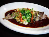 Chinese-style steamed fish in soy sauce and spring onion ... image